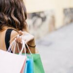 Femme sujette aux achats impulsifs sortant d'un magasin avec des nouveaux achats